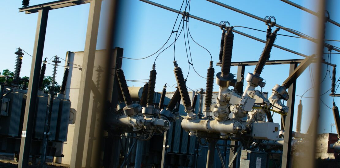 Poste électrique haute tension, disjoncteurs et isolateurs sous un ciel dégagé