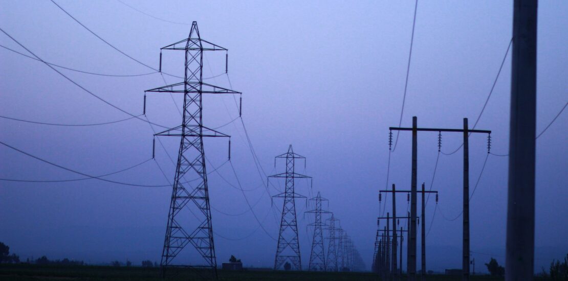 Lignes électriques à haute tension au crépuscule, illustrant la vulnérabilité des infrastructures critiques